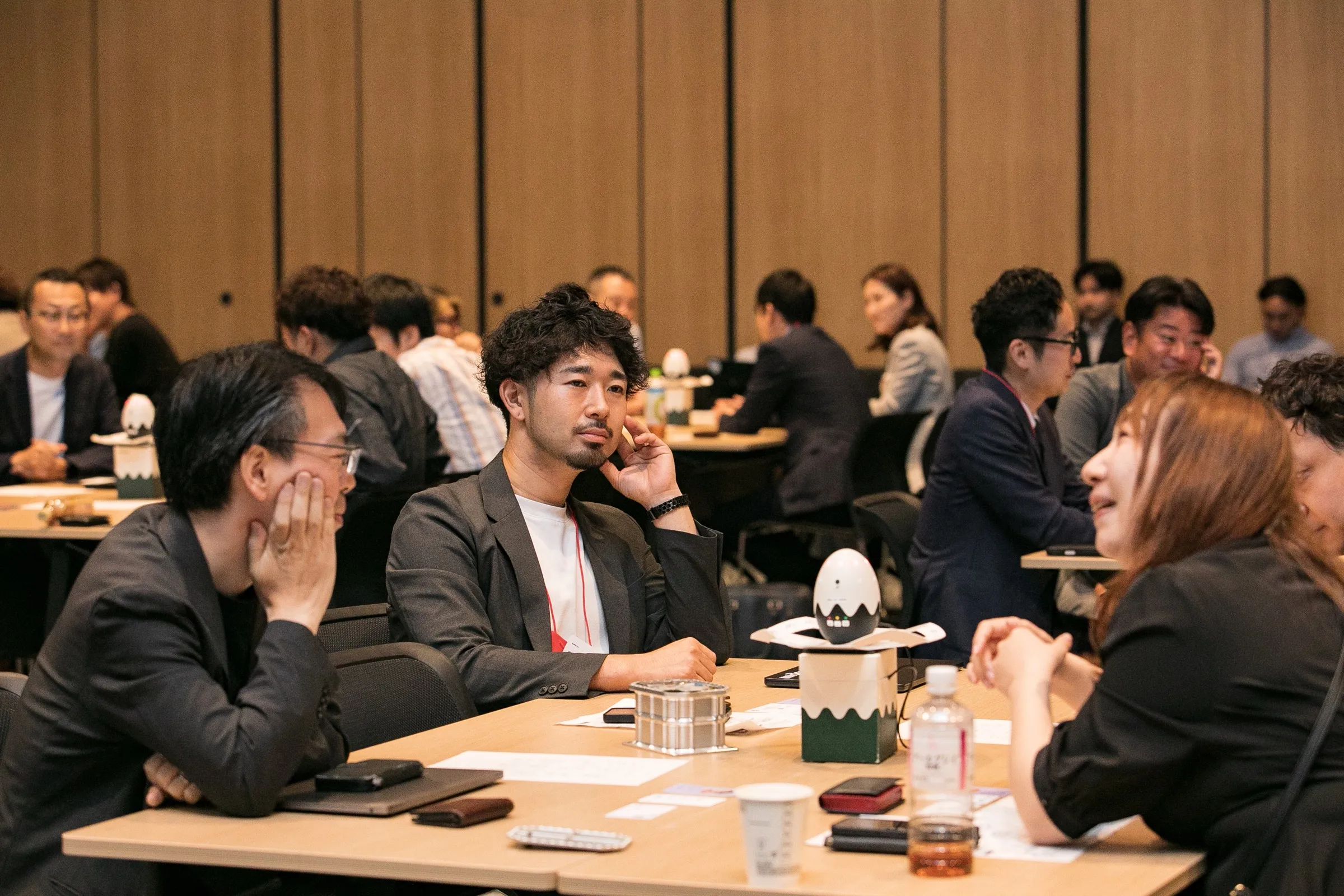 複数のテーブルで参加者が対話している会場