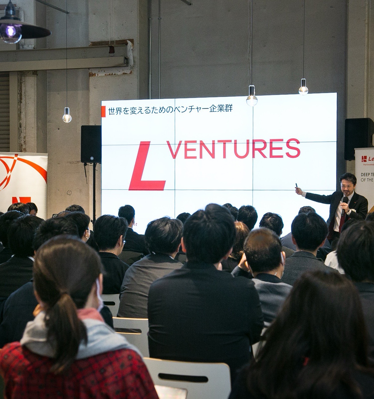 壇上で「世界を変えるためのベンチャー企業群 L VENTURES」を語るリバネス代表